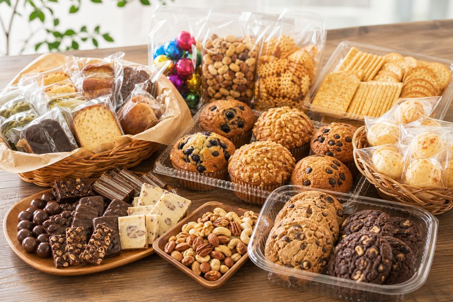 手土産・差し入れのイメージ。小分けにしたマフィン、クッキー、パウンドケーキ、チョコレート、ナッツ